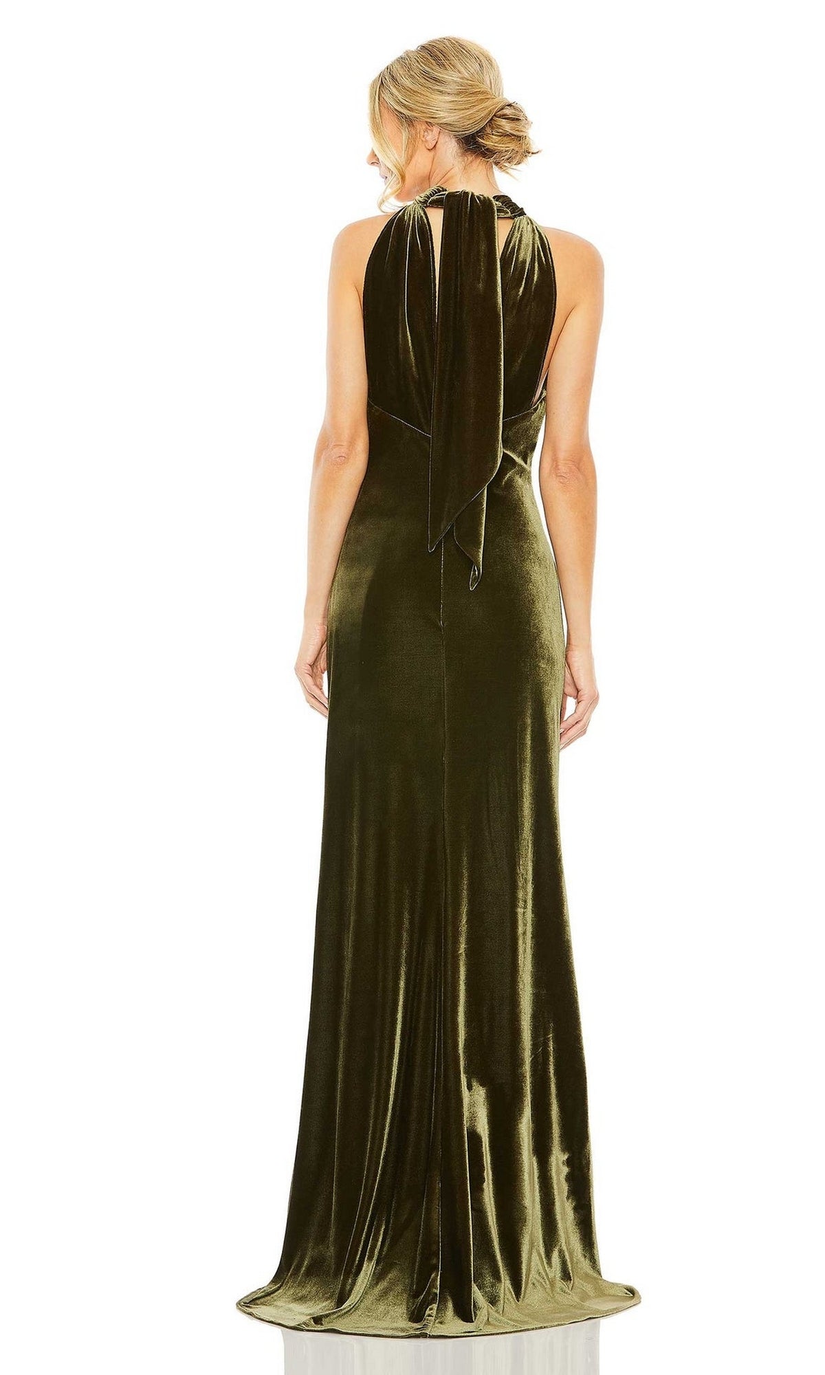A woman wears the Long Formal Dress 55954 by Mac Duggal in olive green velvet, facing away to display its floor-length fitted skirt and elegant draped back.
